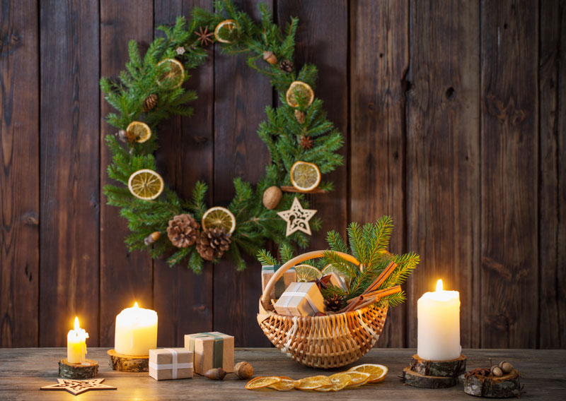 Couronne de Noël réalisée avec branches de sapin, fruits secs et de pommes de pin.