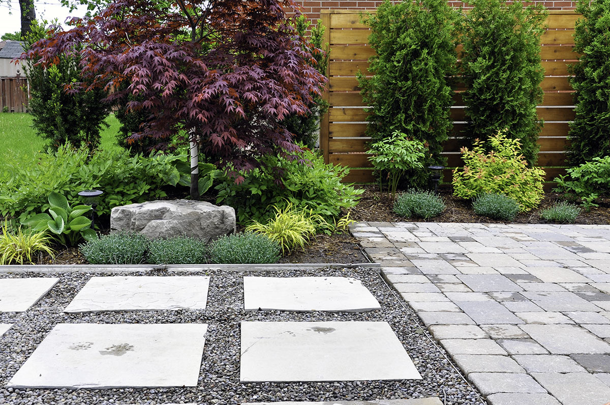 Allée de jardin réalisée avec des dalles en pierre.