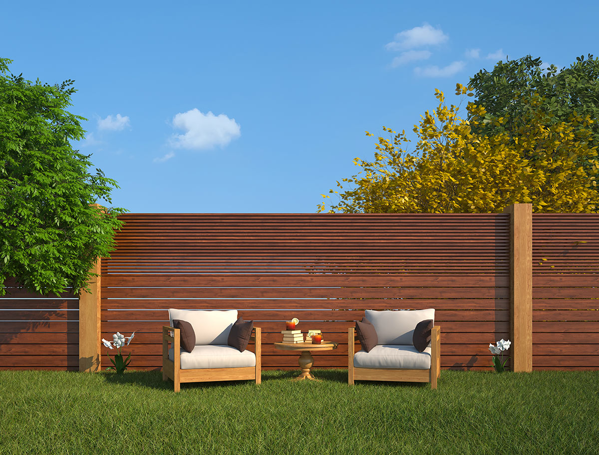 grande clôture de jardin en bois avec planches orizontales, 2 fauteuils d'extérieur avec table basse.
