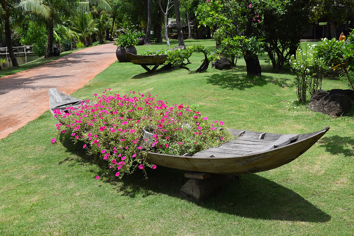 Vieille barque décorée avec des fleurs dans le jardin.