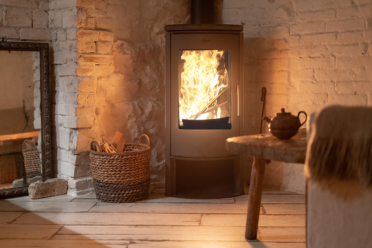 salon avec cheminée et panier en osier pour ranger le bois.