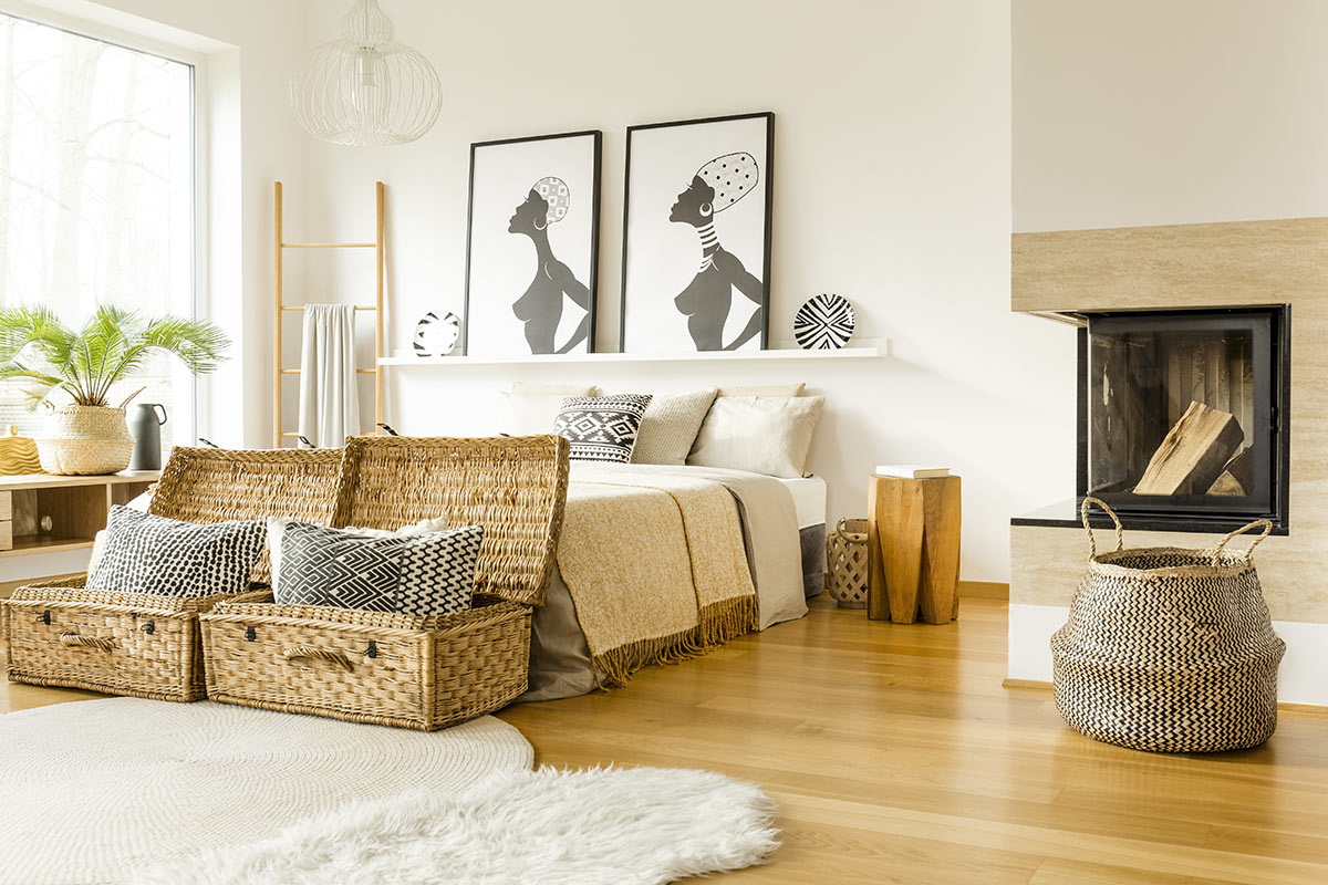 Chambre moderne avec tableaux africains et deux beaux paniers en osier au pied du lit.