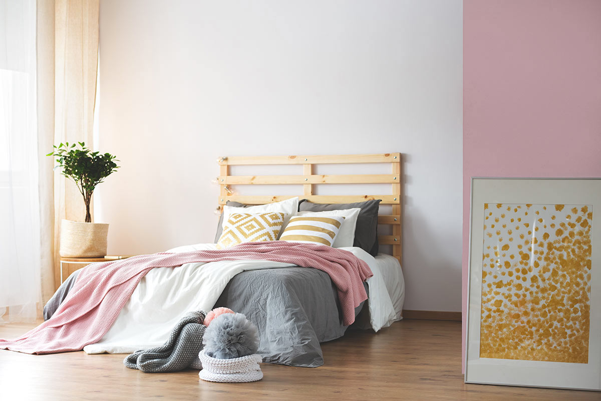 tête de lit DIY avec palettes dan dcette chambre avec mur blanc et rose