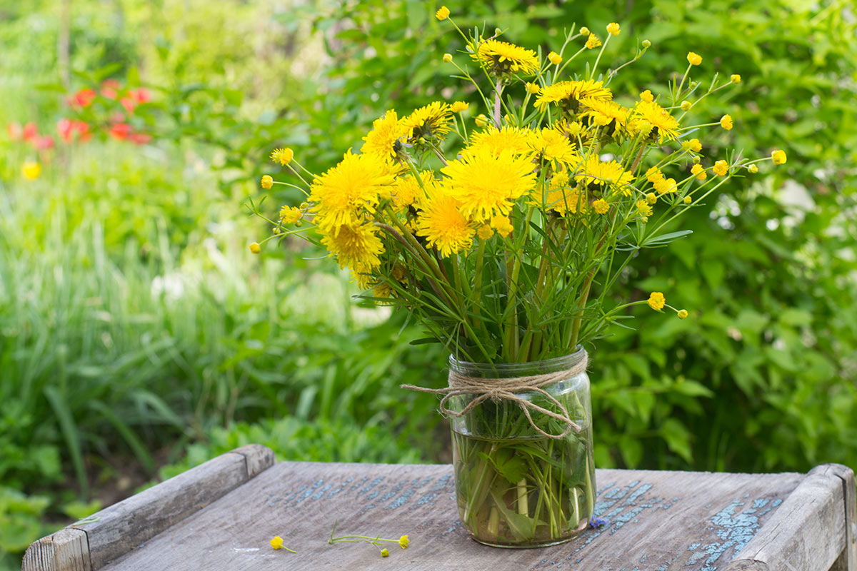récipient en verre recyclé avec fleurs jaunes