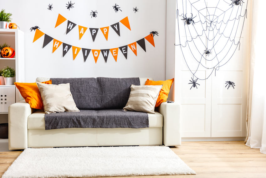 festons oranges et noirs, des araignées et des toiles d'araignées sur le mur pour Halloween