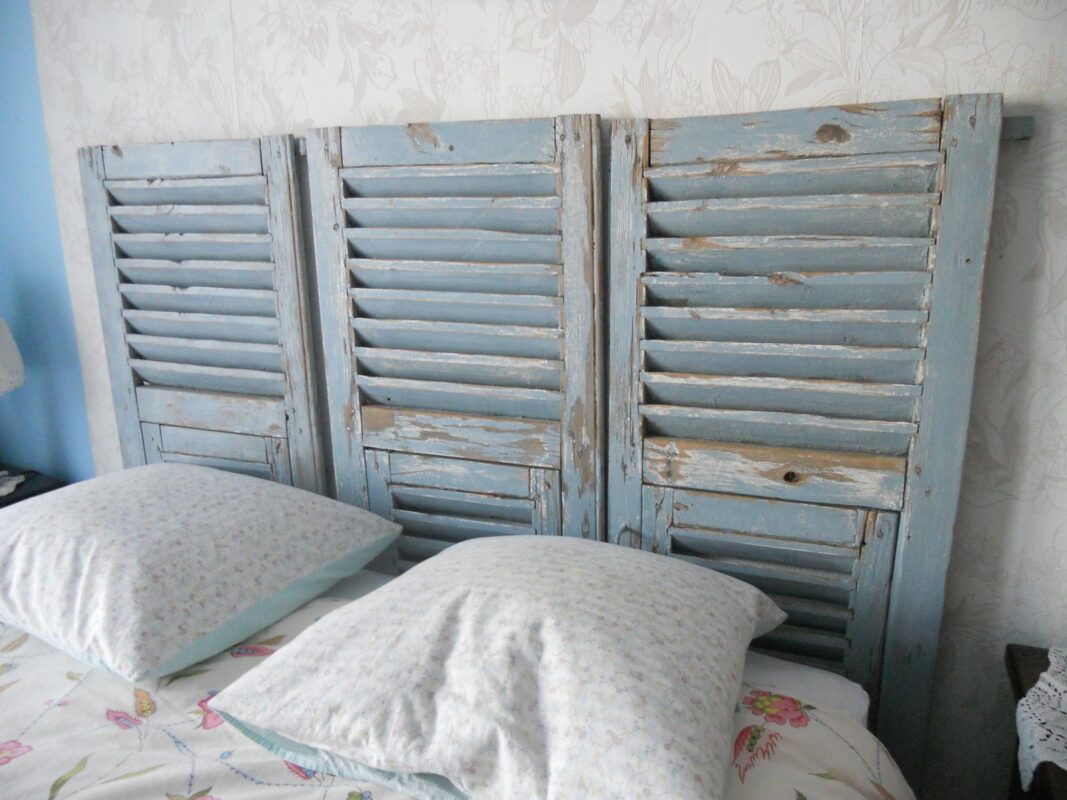 Tête de lit shabby avec de vieux volets bleus.