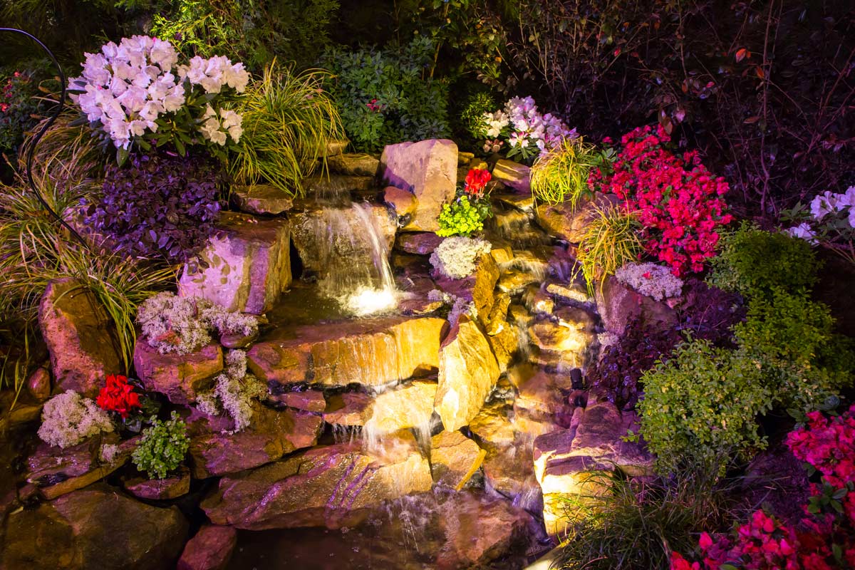 belle fontaine de jardin éclairée par des projecteurs