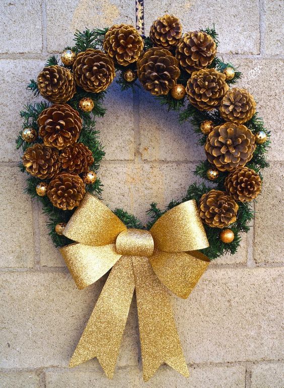 splendida corona natalizia realizzata con pigne e fiocco oro