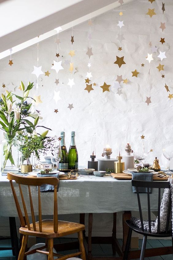 Des étoiles dorées suspendues au plafond pour décorer la maison le soir du Nouvel An.