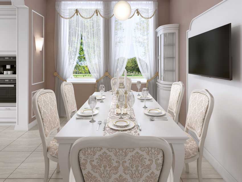 Salle à manger country chic avec table blanche et belles chaises, murs taupe et blancs.