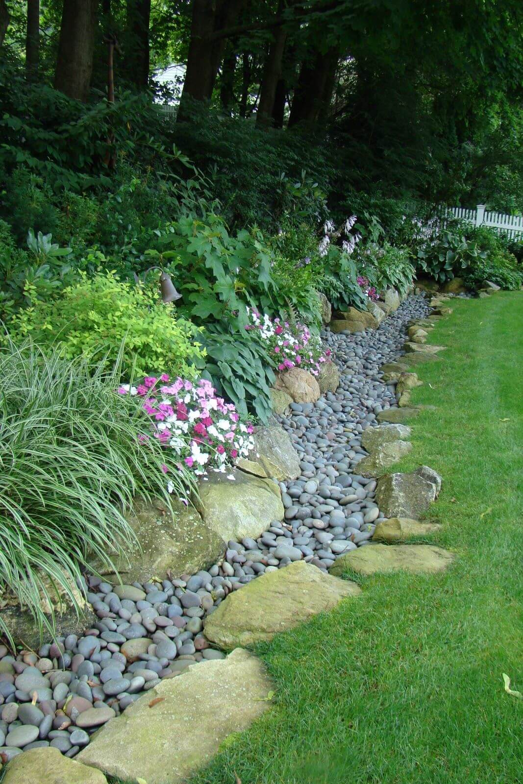Bordo del giardino con pietre di fiume grandi e piccole