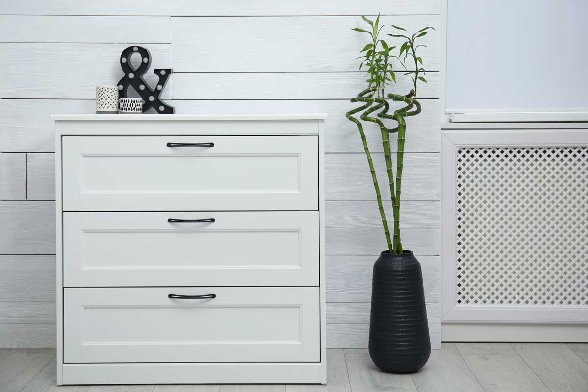 Décoration shabby avec table de chevet blanche et vase noir avec Lucky bamboo.