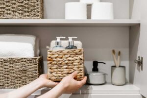 Paniers en osier sur étagères de rangement dans la salle de bain.