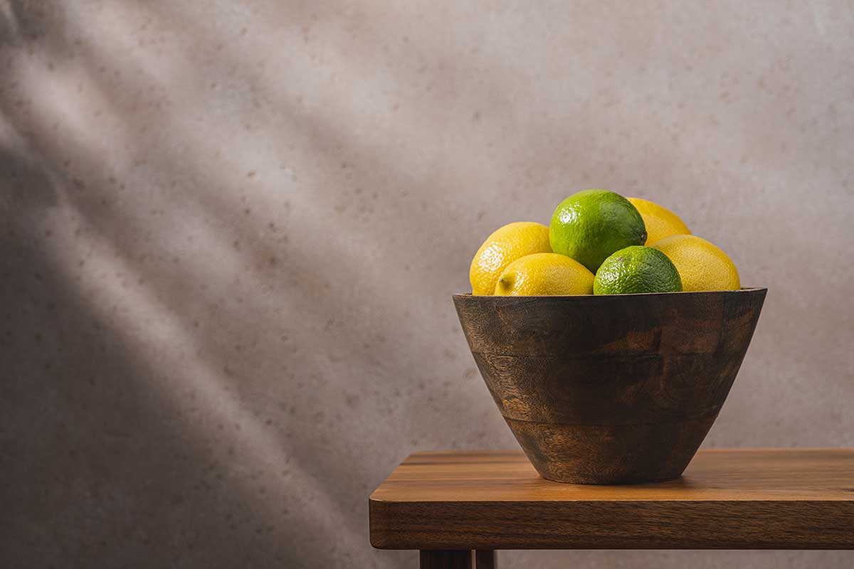 citrons jaunes et verts dans un pot sur une table