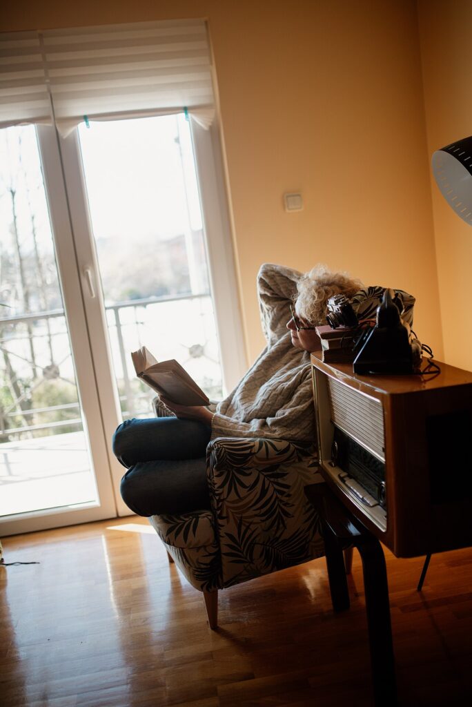 Un divan rose… J’ose! 20 idées pour l’intégrer dans sa déco… - A person sits comfortably in a warm, sunlit room, relaxed while reading a book. Nearby,
