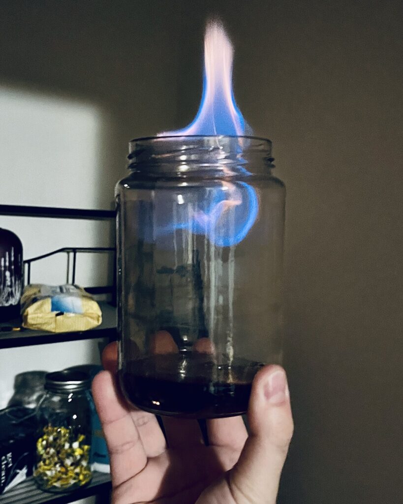 Bocaux en verre - A jar of acetone used to remove resinous build-up that has been set aflame.