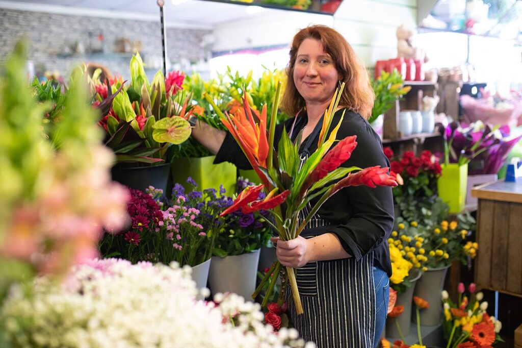 Le balcon en fleurs! 15 idées qui sauront vous inspirer… - Photograph of a florist in a shop holding some flowers she has just selected to make into a