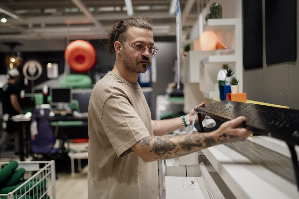 7 belles idées déco en pierre pour donner une touche de caractère à votre intérieur - Man adjusting black shelving in a modern home decor store