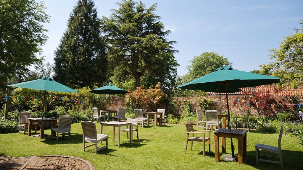 Aménagement jardin en pente - Garden with café furniture at Paycocke's House and Garden, Coggeshall, Essex, England.To see allied photos, click on thi